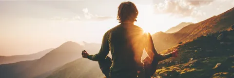 Outdoor meditation and yoga session on a mountain top during a scenic sunset.